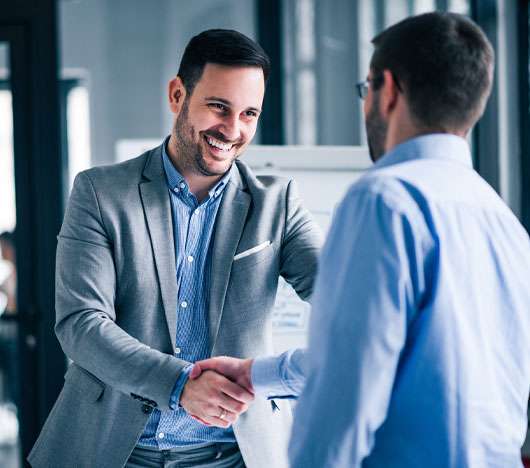 Business man happily shaking hands with a satisfied customer.